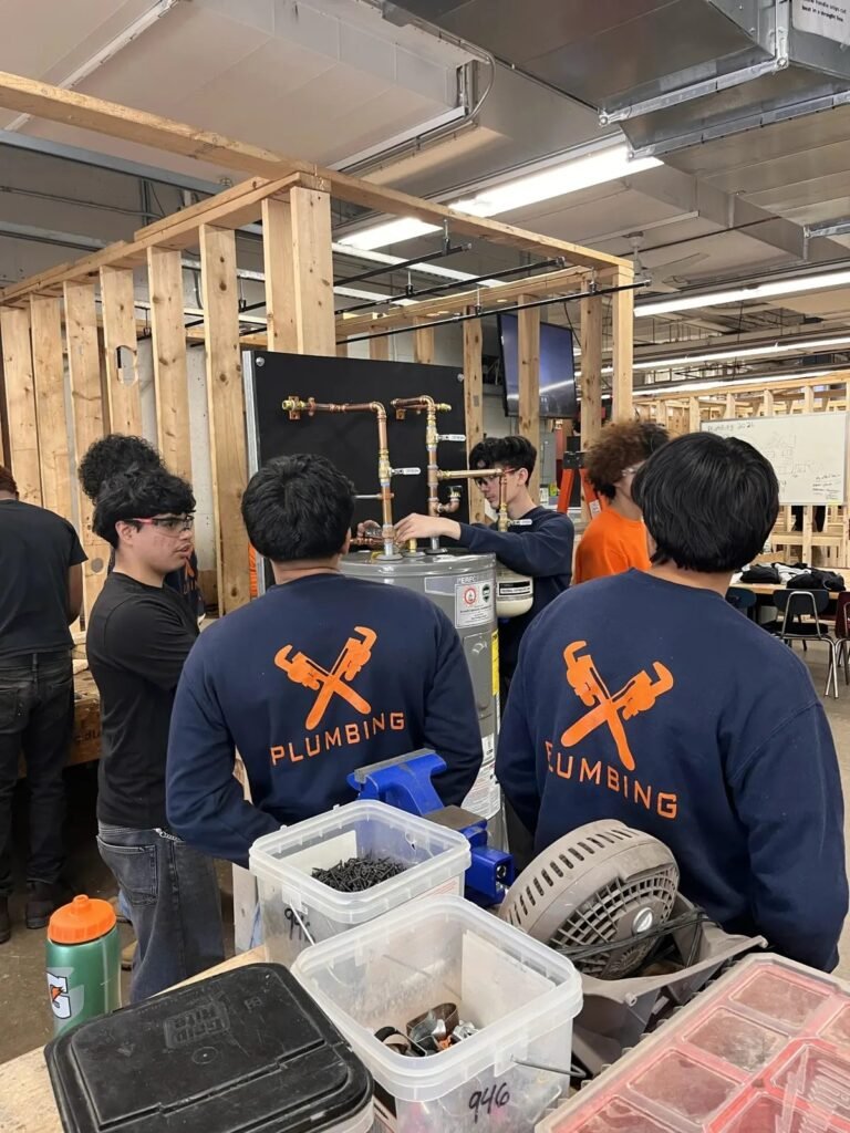 Students connecting copper piping on the training rig